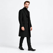Homem usando sobretudo longo preto em nova pose de três quartos, fundo branco.