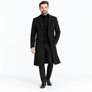 Homem usando sobretudo masculino longo preto em estúdio com fundo branco.