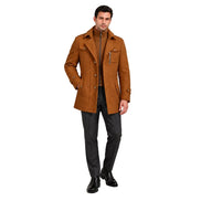 Modelo usando sobretudo masculino caramelo Terno Lux em estúdio, vista frontal com uma mão no bolso.