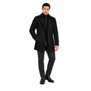 Modelo usando sobretudo masculino preto Terno Lux em estúdio, vista frontal com uma mão no bolso.