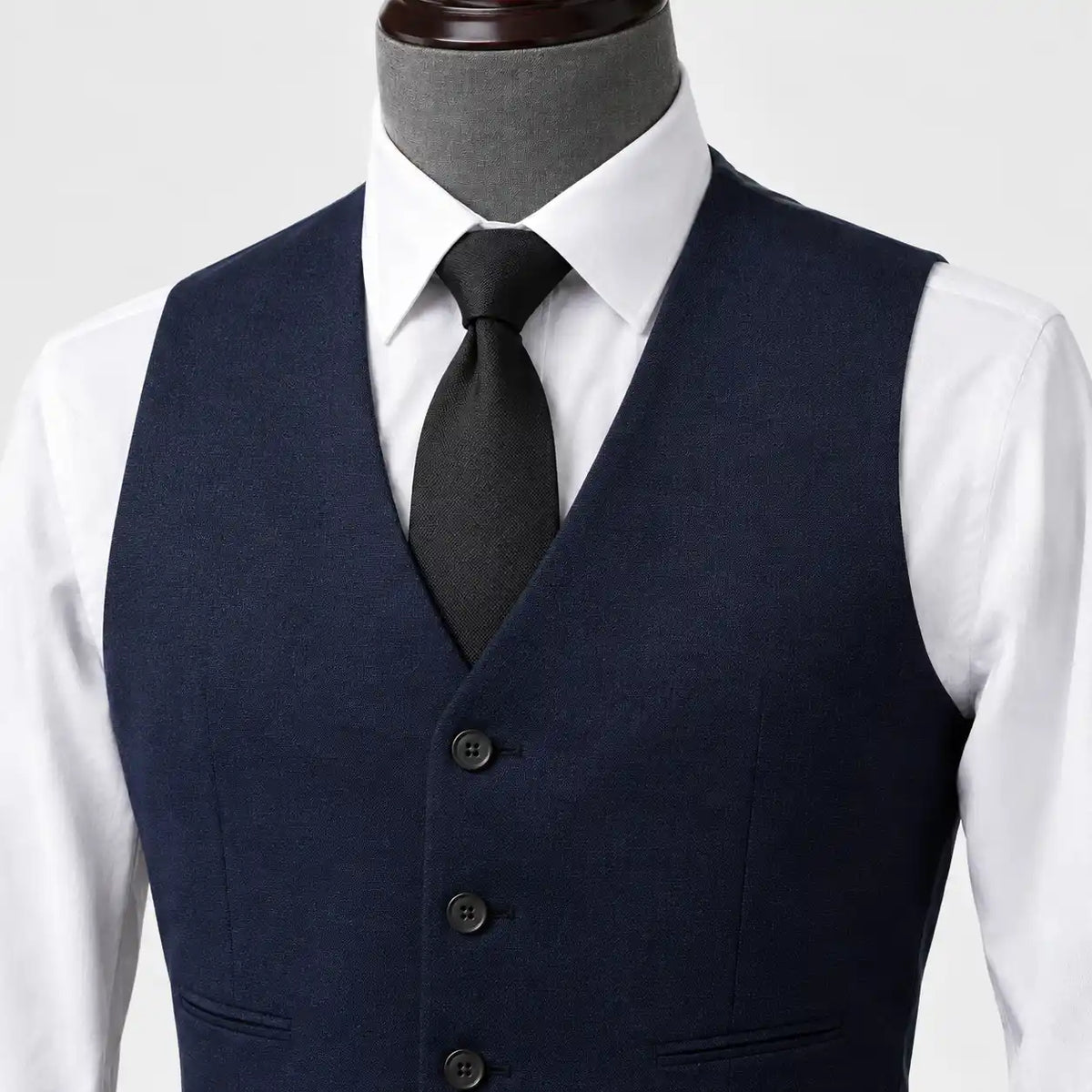Detalhe do colete do terno azul marinho com camisa branca e gravata preta